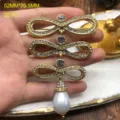 Vintage palace style multi-layer bow brooch with sparkling rhinestones and pearl drop. - Bronze