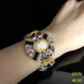 Vista detallada del brazalete vintage con camafeo, pedrería morada y elegante diseño dorado. - Pulsera