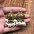 Close-up detail of vintage gold-tone dome pearl jhumka earrings showing intricate texture. - HE711 Pearl Stud Earrings