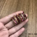 Primer plano detallado de pendientes dorados con cristales rosas y brillantes strass. - Pendientes de botón / Rosa