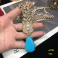 Detalle de primer plano de collar hoja de estrás oro vintage con gota de turquesa. - Collar de Turquesa