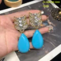 Vista detallada de los pendientes vintage con plumas de flecha de pedrería y gotas azules. - Pendientes de Botón Turquesa
