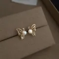 Exquisites Detailfoto von minimalistischen goldenen Schmetterling Perlen Ohrsteckern. - Süßwasserperle Schmetterling Ohrstecker (4143)