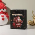 Black Christmas gift bag with Santa Claus graphic and festive lettering for holiday packaging. - Style 2 (696-2) / 18x10x23cm