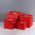 Detail view of thickened red square paper gift bags with wide bottom and ribbon handles. - 15x15x15cm / Red