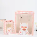 Sacchetto regalo a quadri rosa con orsetto carino e finestra, ideale per compleanno bambini e festa. - Quadri Rosa Bianco - Orso