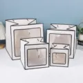 Vue détaillée de sacs cadeaux blancs avec fenêtre transparente de différentes tailles. - Blanc avec cadre noir
