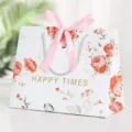 White paper gift bag with rose floral print, pink ribbon bow and silver handles for party. - Romantic Flowers-Small (18x10x16cm)