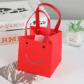 Rode papieren cadeautas met lachende gezichtsnede, ideaal voor verjaardagsfeestjes en cadeaus. - 15*15*15cm / Vrolijk rood