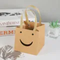 Bruine kraftpapieren geschenkzak met schattige smiley uitsnede, kleine draagtas variant ontwerp. - 15*15*15cm / Kraftpapier Kleur