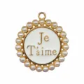 Close up detail of round metal shoe charm with pearl border and French text enamel insert. - 906-09