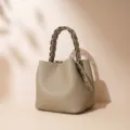 Elegante bolso bombonera de cuero genuino con asa trenzada, bolso cruzado taupe versátil. - Gris peltre