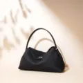 Bolso de hombro clásico negro de piel con asa superior y diseño minimalista elegante. - Negro