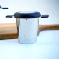 Stainless steel tea infuser with fine mesh, black handle and lid for home and outdoor use. - Tea Strainer (With Lid & Silicone)