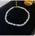 Gros plan détaillé d'un élégant collier de perles baroques françaises avec fermoir doré. - Collier-Blanc