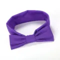 Detailopname van de schattige paarse stoffen strik haarband, met zachte textuur en nette stiksels. - Donkerpaars