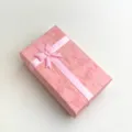 Scatola regalo rosa dolce con fiocco, vista di dettaglio perfetta per imballaggio gioielli. - Rosa