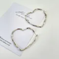 Orecchini a cerchio a cuore argento da donna, stile minimalista metallico alla moda. - Cuore Intrecciato Argento