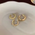 Detailaufnahme von drei minimalistischen Goldohrringen mit Zirkon und Kettendesign. - Gold Quaste 3-Teiliges Set / Gold