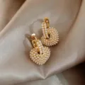 Detailaufnahme von Perlen Herz Creolen mit feiner Perlentextur und elegantem Goldglanz. - Herzanhänger / Vergoldet Gold