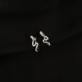 Detailed shot of silver-colored snake ear cuffs, non-pierced design, chic sweet style. - Snake Style