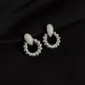 Silver metal twisted hoop earrings with pavé crystal top, trendy chic daily fashion detail shot. - Screw Back