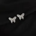Close-up detail of sparkling zirconia butterfly ear clips, elegant silver tone metal design. - Zircon Butterfly Style