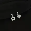 Close-up detail of trendy asymmetric silver clip-on earrings featuring cute flower and heart charms. - Asymmetric Heart Flower Style