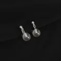 Close-up detail of transparent glass ball drop earrings with silver metal chain clip. - Glass Ball Style