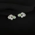 Close-up of unique metal clip earrings featuring green stone accents, intricate design. - Green Aventurine Style