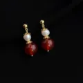 Detaillierte Nahaufnahme von eleganten vergoldeten Perlen und roten Perlen Ohrringen im Detail. - Süßwasserperle Roter Achat Stil (E463) / Weinrot Süßwasserperle Roter Achat Moskito-Spulen-Clip