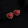 Close-up view of elegant burgundy red heart earrings with gold rim, retro jewelry design. - Wine Red Gold Rim Heart Mosquito Coil Clip
