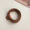 Close-up detail of a brown elastic hair tie featuring a charming handmade leather label. - Brown Bear Tag Style (3383)