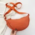 Orange nylon crescent shoulder bag, stylish casual dumpling crossbody bag for women daily use. - Orange