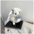Close up of cute plush alpaca bag with soft white fleece and elegant grey bow details. - White