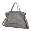 Close-up of the grey PU leather shoulder bag featuring rivet details and tassel accent. - Gray