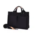 Detail view of black canvas tote bag with front pockets and durable leather handles. - Black