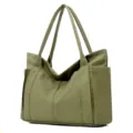Detail view of the army green canvas tote bag featuring durable handles and side pocket storage. - Army Green