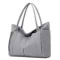 Detailed view of the large capacity gray canvas tote bag with multiple pockets and shoulder straps. - Gray