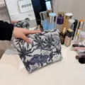 Cosmetic bag detail shot, portable woven makeup pouch with blue palm print for travel vanity. - Tree