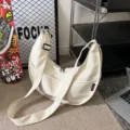 Detail view of a Korean style solid color crescent shoulder bag large tote casual canvas. - Off White