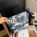 Gros plan sur la trousse de maquillage tissée à motif botanique bleu et blanc en détail. - Motif d'arbre