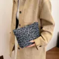Detail shot of the grey floral cosmetic pouch, showing the compact and portable storage design. - Black Textured Bubble Flowers