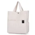 Minimalist off-white canvas tote bag with dual handles, front pockets and magnetic snap. - White