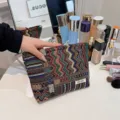 Boho ethnic style woven cosmetic bag, detailed close-up of colorful geometric pattern pouch. - Ethnic