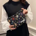 Detailed view of the woven floral cosmetic bag featuring unique ethnic jacquard texture. - Jacquard Linen Petals Black