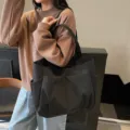 Stylish black minimalist canvas shoulder tote bag with multiple exterior pockets for women daily commute. - Black