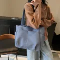 Minimalist solid color canvas tote bag with multiple outer pockets, casual shoulder bag. - Blue
