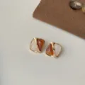 Nahaufnahme von geometrischen zweifarbigen Ohrringen mit braun-weissem Design. - Kreativer Kontrastkaffee (2425)