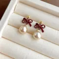 Detaillierte Nahaufnahme von burgunderroten Schleife Kunstperle Ohrringen, eleganter Schmuck. - Ohrstecker / Weinrot Perle Schleife (5017)